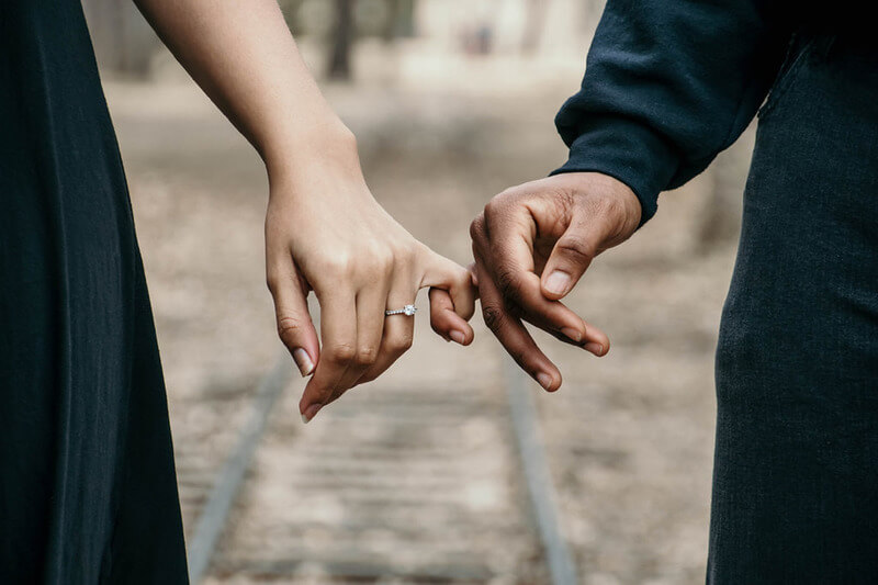 Engagement rings or possibly a wedding. A couple hold hands